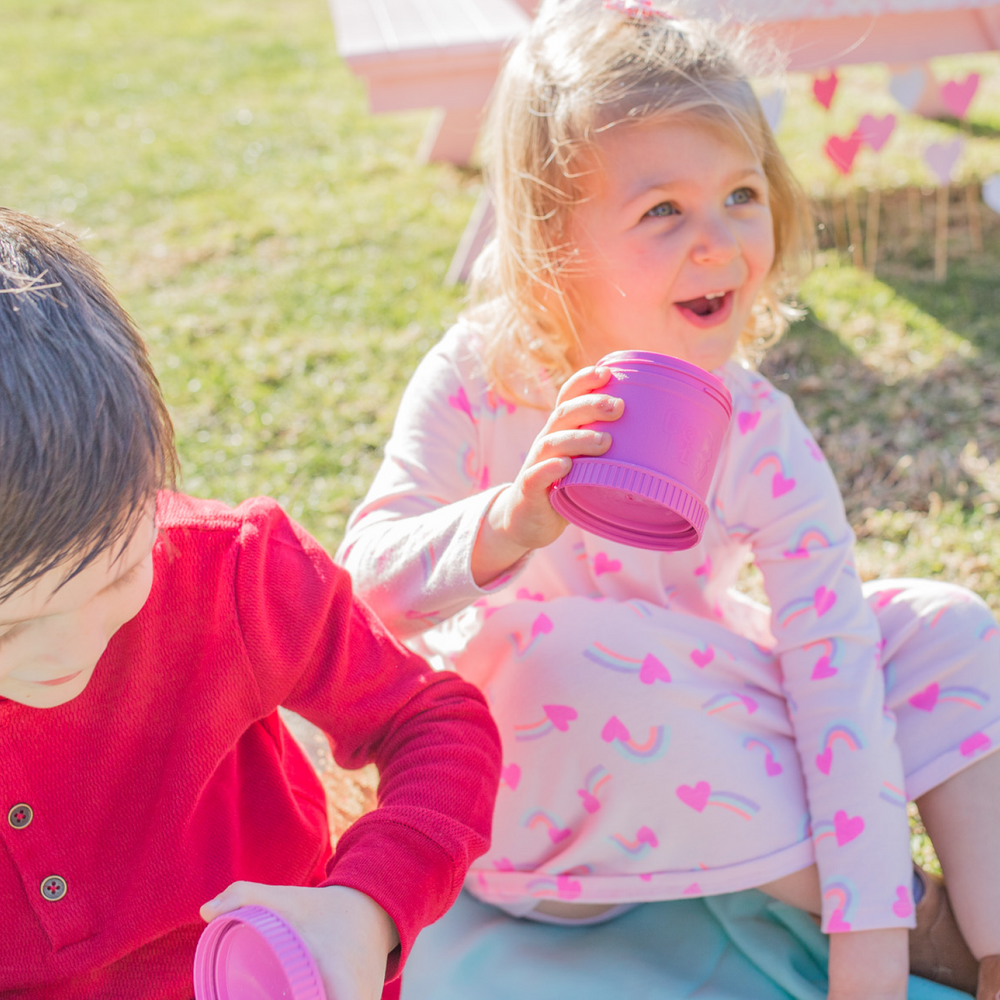 Niños al aire libre con envases Re-Play tapados