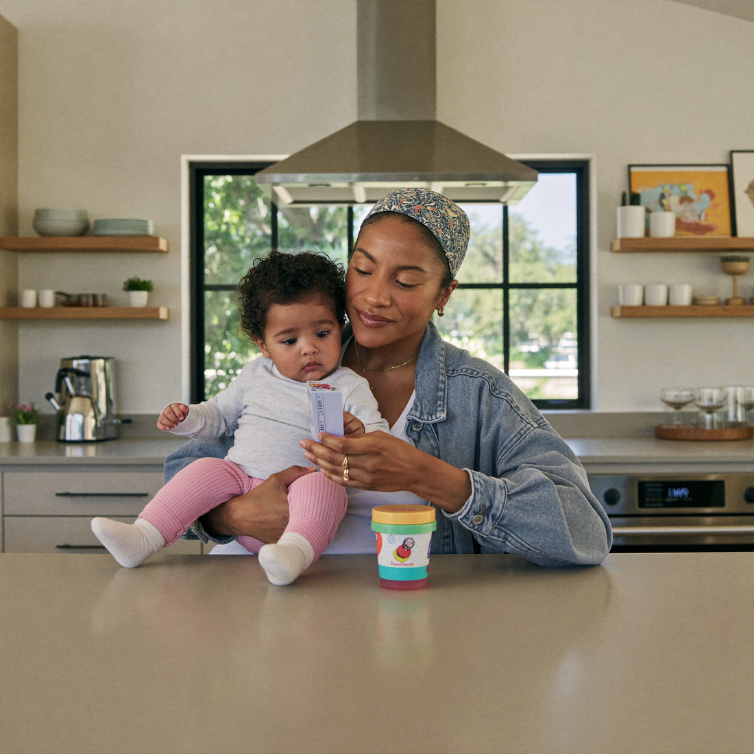 Mamá leyendo la etiqueta de un vaso infantil en su cocina